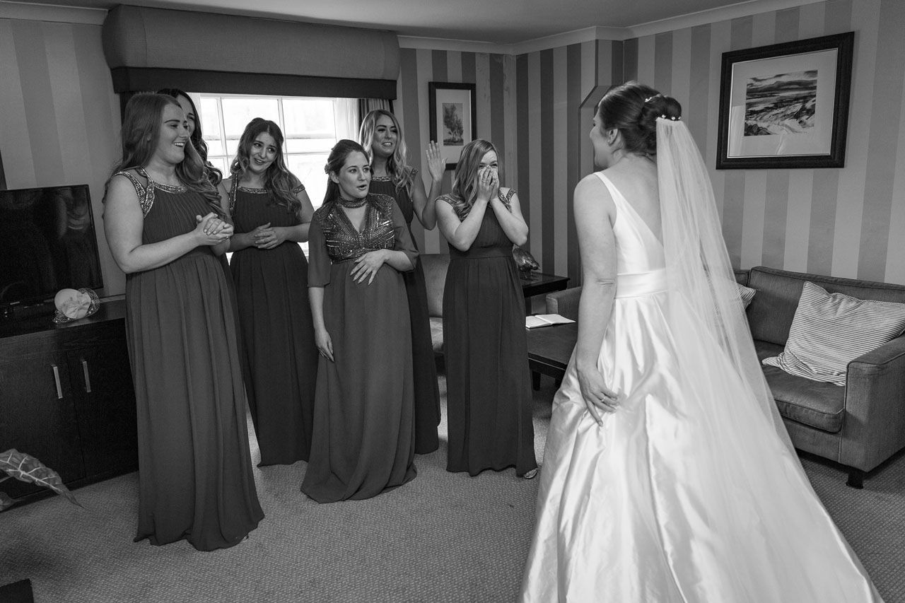 Liz's Bridesmaids seeing her in her wedding dress for the first time. Veiled Productions - Pembroke Lodge Wedding Videographer -Liz And Luke