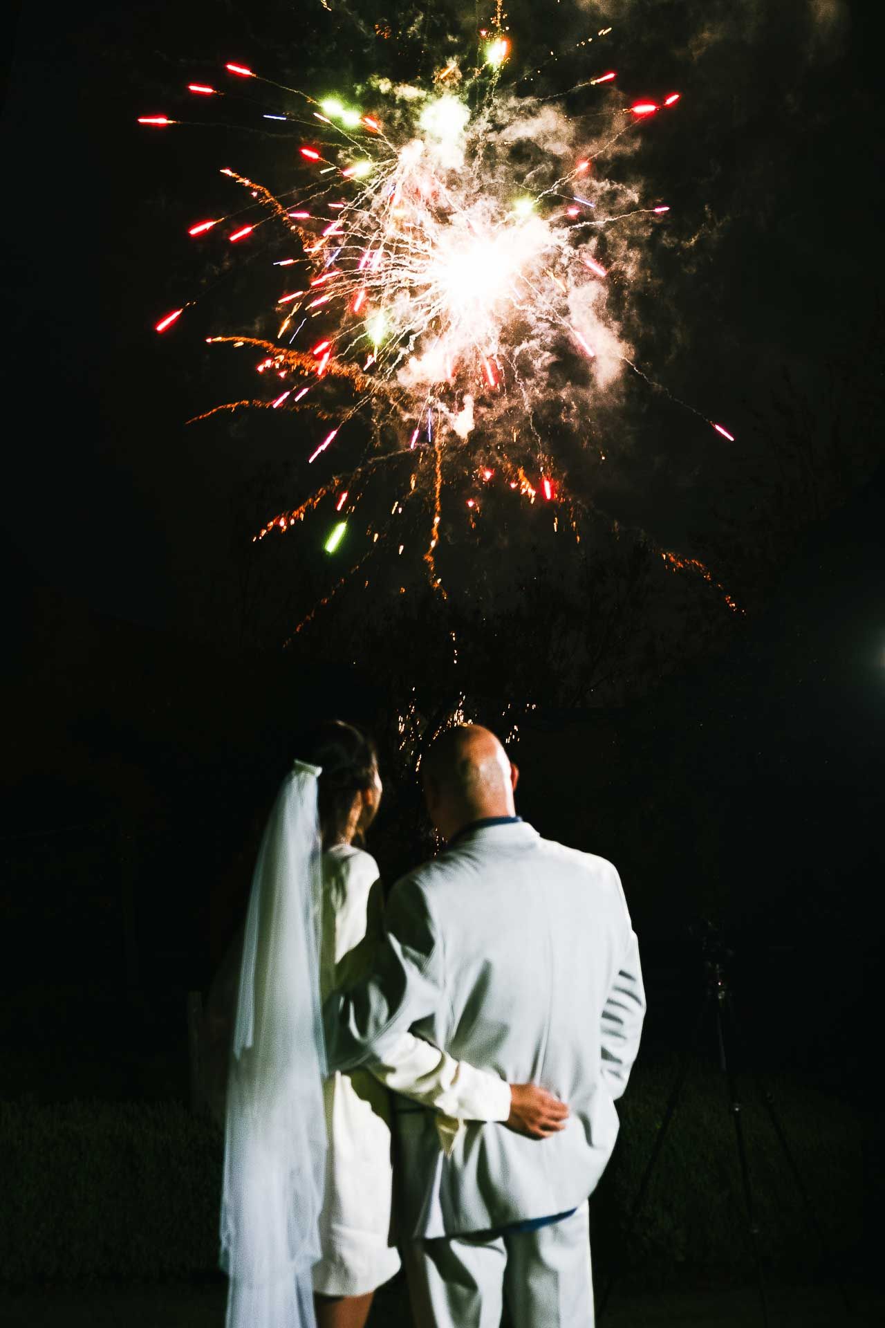 Adrian and Nadia watching fireworks by Star Fireworks UK that concluded their wedding celebrations. Orange and green fireworks light up the sky whilst Adrian and Nadia look up with their backs to the camera. Mark Cairns - a mind reader and magician entertainer for weddings and events - wowing guests with his tricks during Adrian and Nadia's wedding reception. Photo by Des Dubber Photography, videography by Veiled Productions