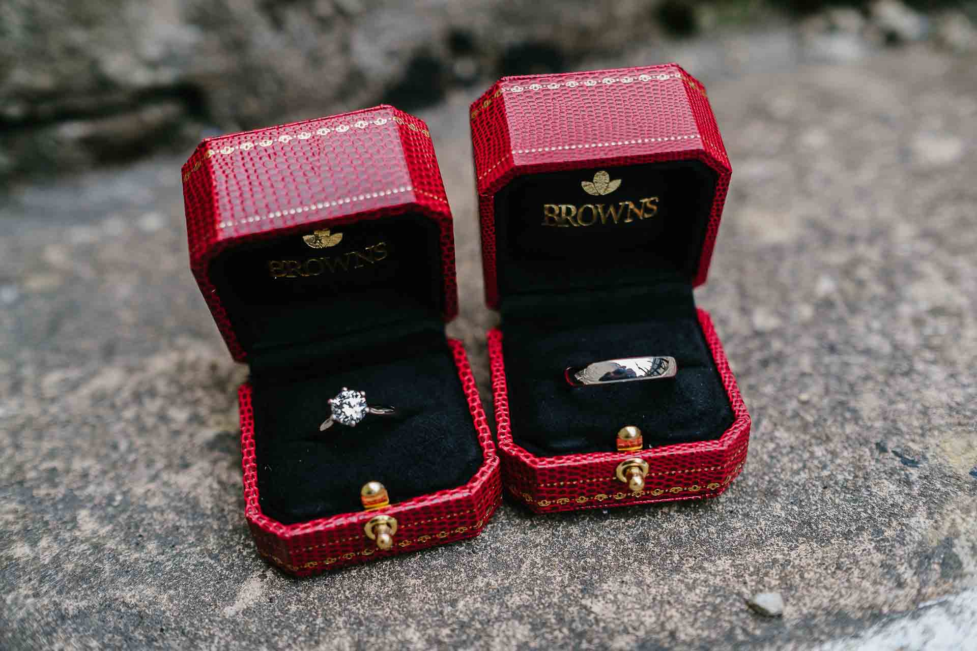 Adrian and Nadia's wedding rings in their red presentation boxes before the ceremony. Photography by Des Dubber Photography. Videography by Veiled Productions.