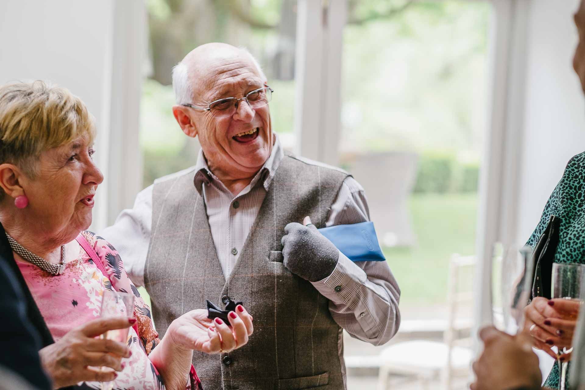 Adrian and Nadia's guests laughing during the drinks reception after the wedding ceremony. Photography by Des Dubber. Videography by Veiled Productions. 