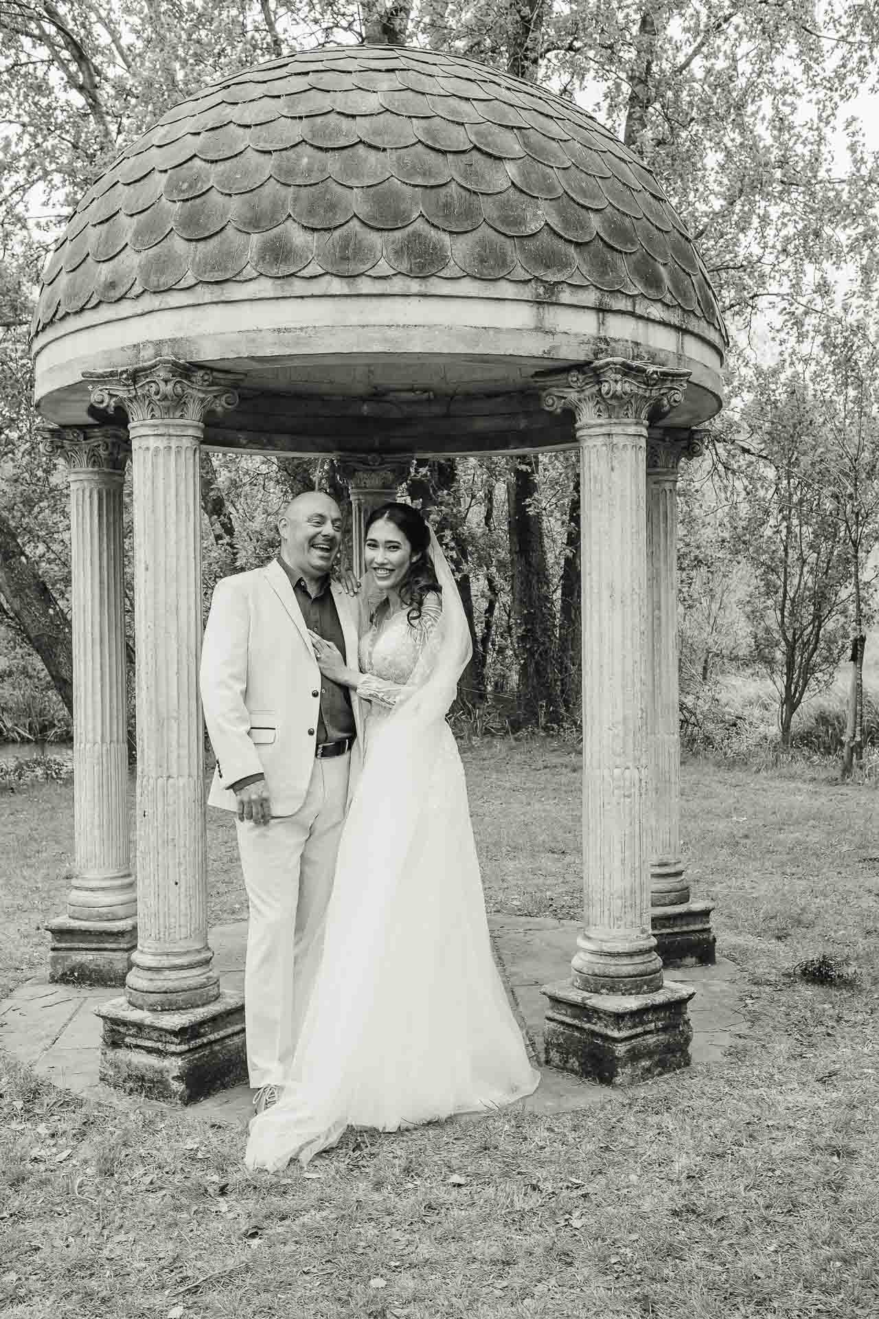 Adrian and Nadia laughing in the gardens of Minster Mill after their wedding ceremony. Photo by Des Dubber Photography, videography by Veiled Productions