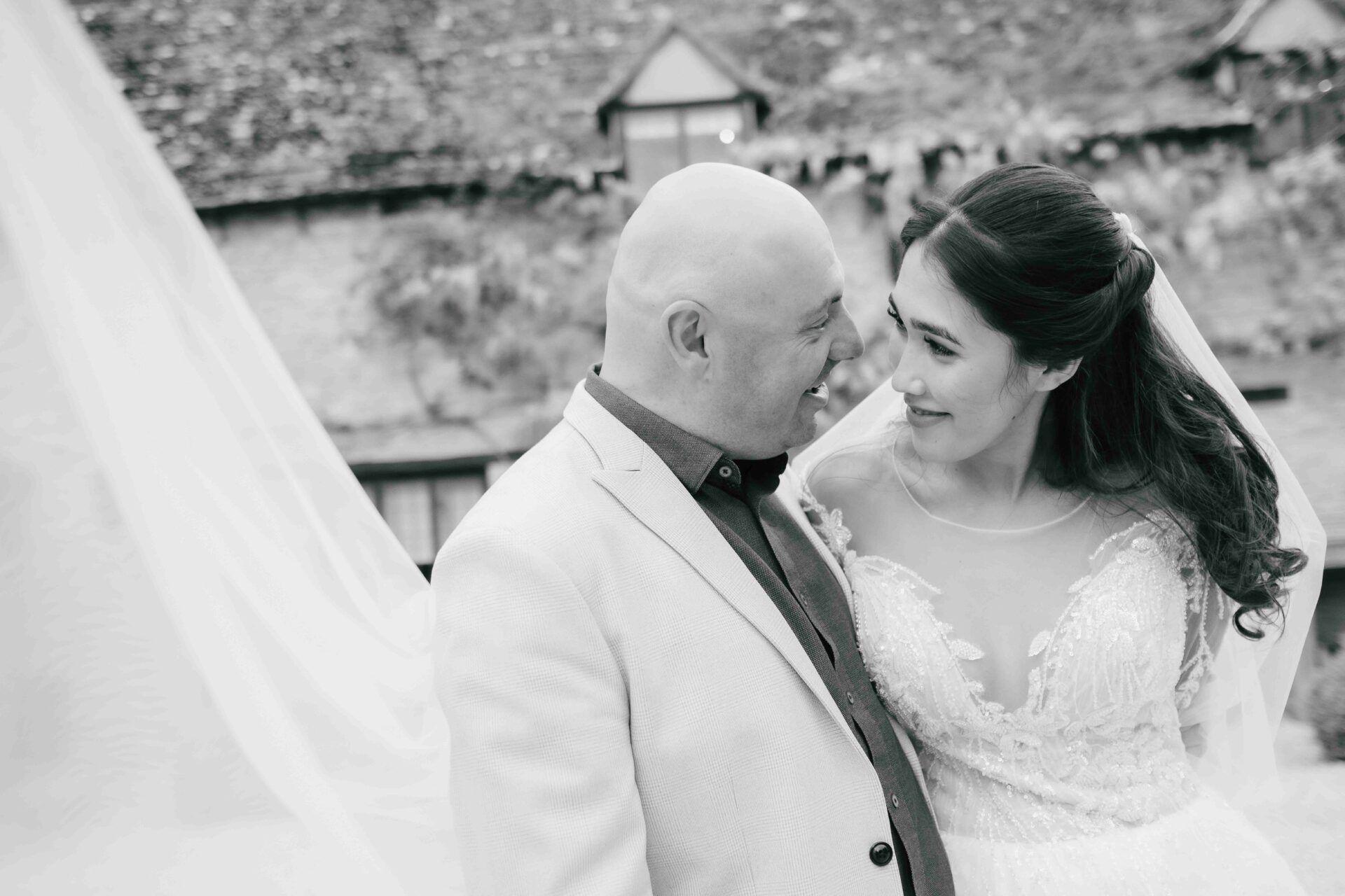 So much love in Nadia's eyes as she looks at Adrian. Her veil in the foreground of the photo with Minster Mill in the background. Photo by Des Dubber Photography, videography by Veiled Productions