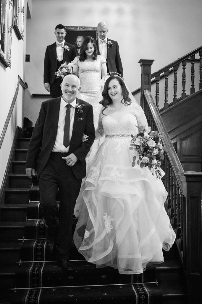 Aimee and her Dad walking down the stairs of Clearwell Castle ready for the wedding ceremony. Photo thanks to Mark Lord Photography.