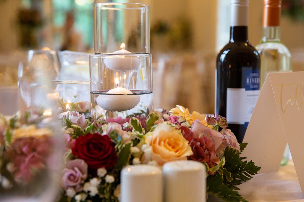 Gorgeous floral centrepiece and candles in vases at Aimee and Simon's wedding. Photo thanks to Mark Lord Photography.