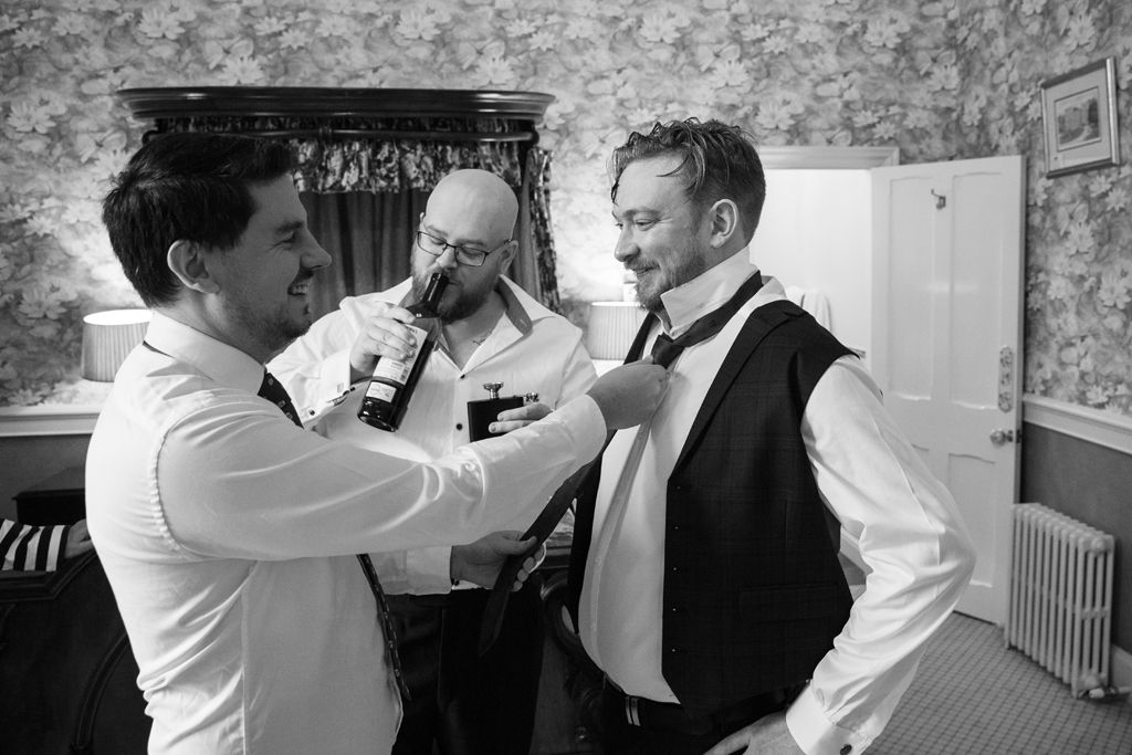 Simon having his tie tied by his best man and groomsmen on the morning of the wedding. Photo thanks to Mark Lord Photography.