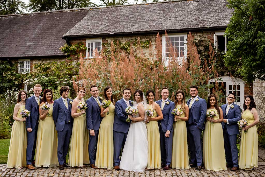 Amy and Mario with their bridesmaids and groomsmen. Wedding photo by Allister Freeman. Videography by Veiled Productions - unique wedding videographer Bury Court Barn