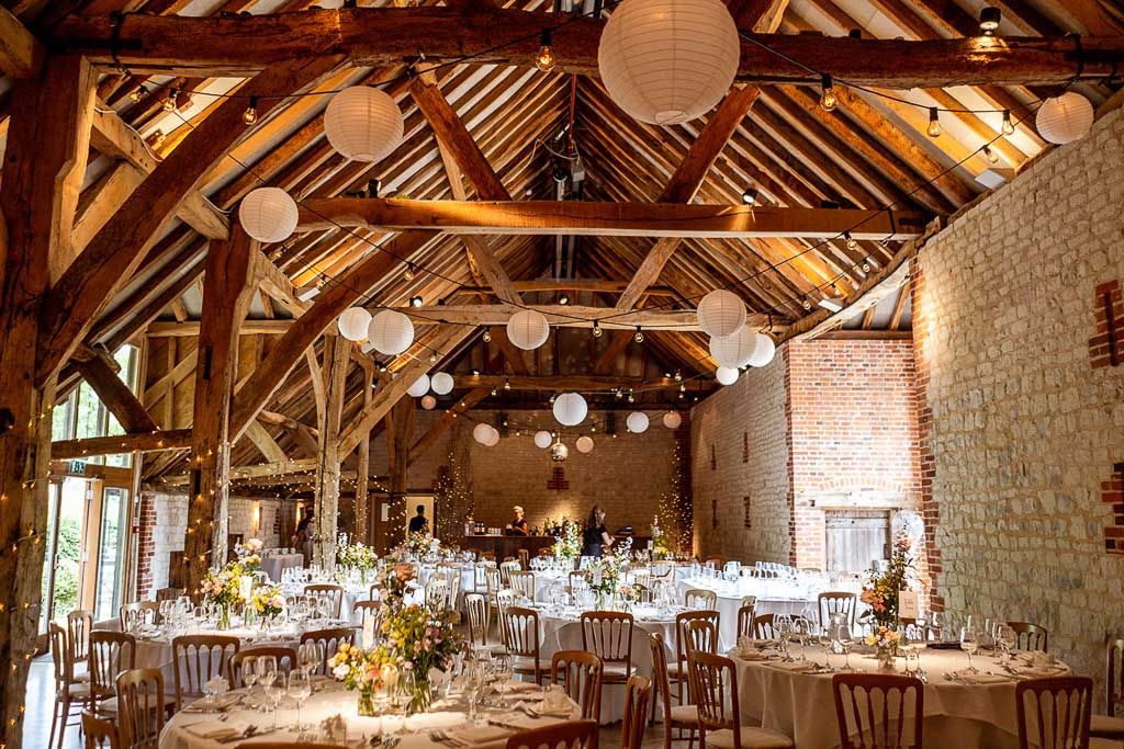 Bury Court Barn dressed for a wedding reception with tables, chairs and lanterns. Wedding photo by Allister Freeman. Videography by Veiled Productions - unique wedding videographer Bury Court Barn