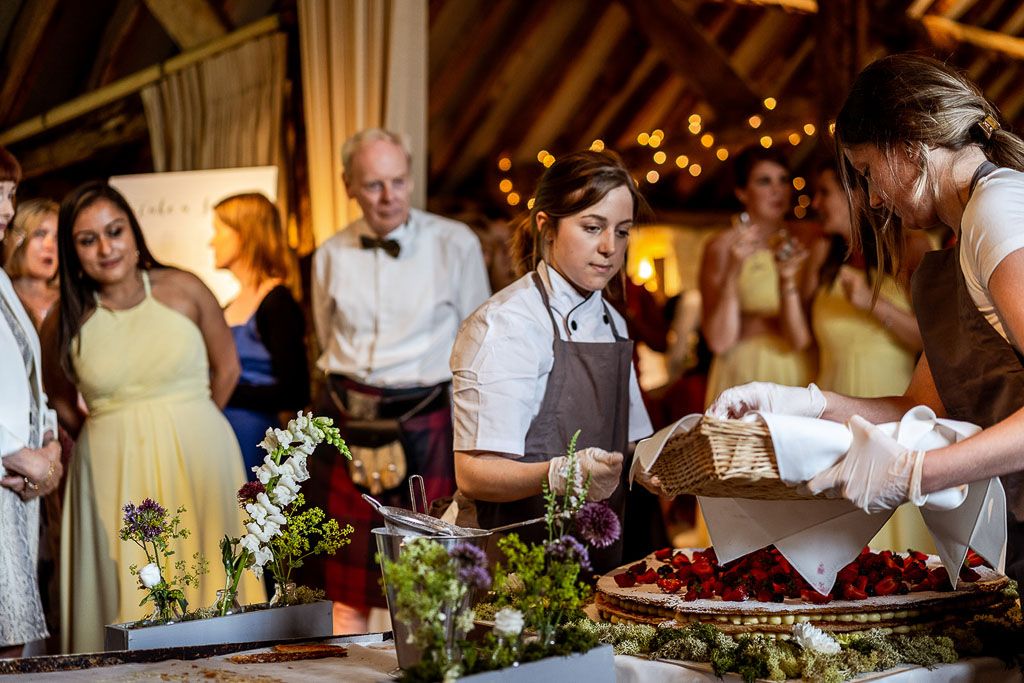 Amy and Mario's wedding cake being constructed in front of their wedding guests following the Italian tradition. Wedding photo by Allister Freeman. Videography by Veiled Productions - unique wedding videographer Bury Court Barn