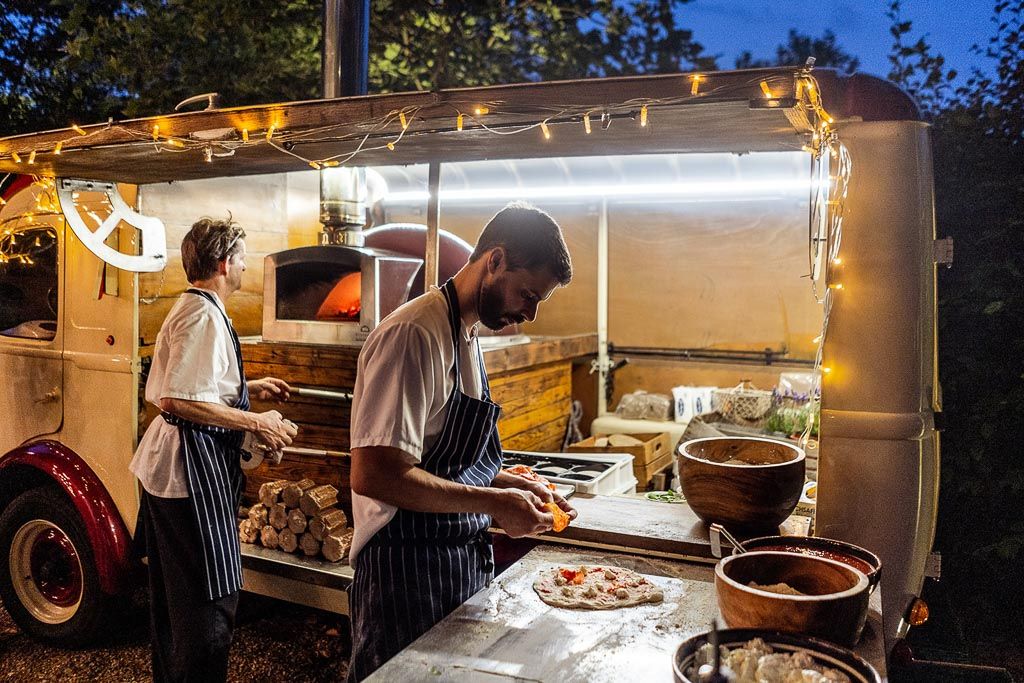 Fresh pizza being prepared in the courtyard of Bury Court. Wedding photo by Allister Freeman. Videography by Veiled Productions - unique wedding videographer Bury Court Barn