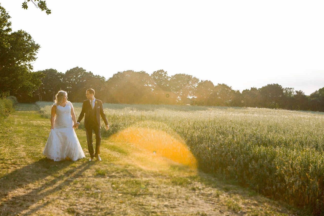 Claire and Andy walking at sunset. Photo thanks to Em J Photography. Colville Hall Wedding Videographer Veiled Productions