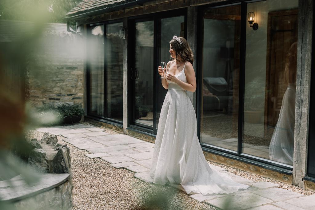 Erin wearing her Sassi Holford wedding dress outside the Nook at The Tythe Barn Launton - Photography by The Kensington Photographer - Videography by Veiled Productions - Tythe Barn wedding videographer