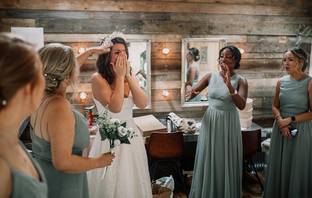 Erin getting emotional surrounded by her bridesmaids after seeing her son and daughter dessed and ready for the wedding - photography by The Kensington Photographer - Videography by Veiled Productions - Tythe Barn wedding videographer
