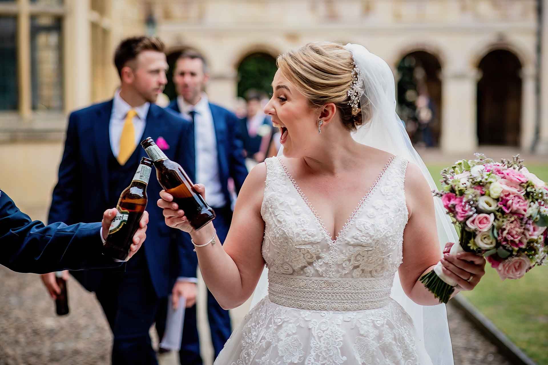 Leah celebrating by clinking her beer bottle with her new husband's and the biggest smile! Photo thanks to Damien Vickers Photography.