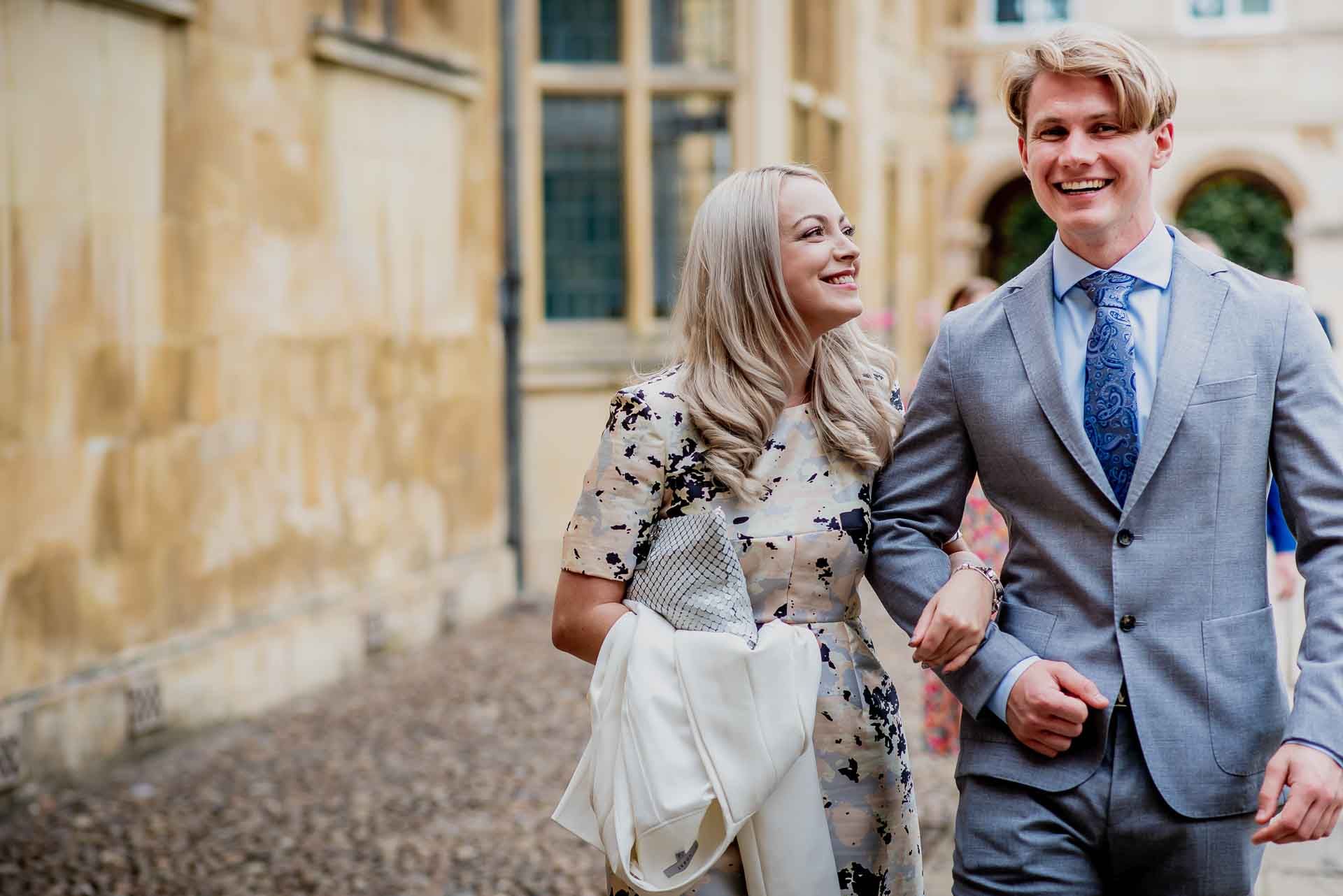 Natural candid photo of guests at Leah and Nic's wedding walking arm in arm and grinning. Photo thanks to Damien Vickers Photography.