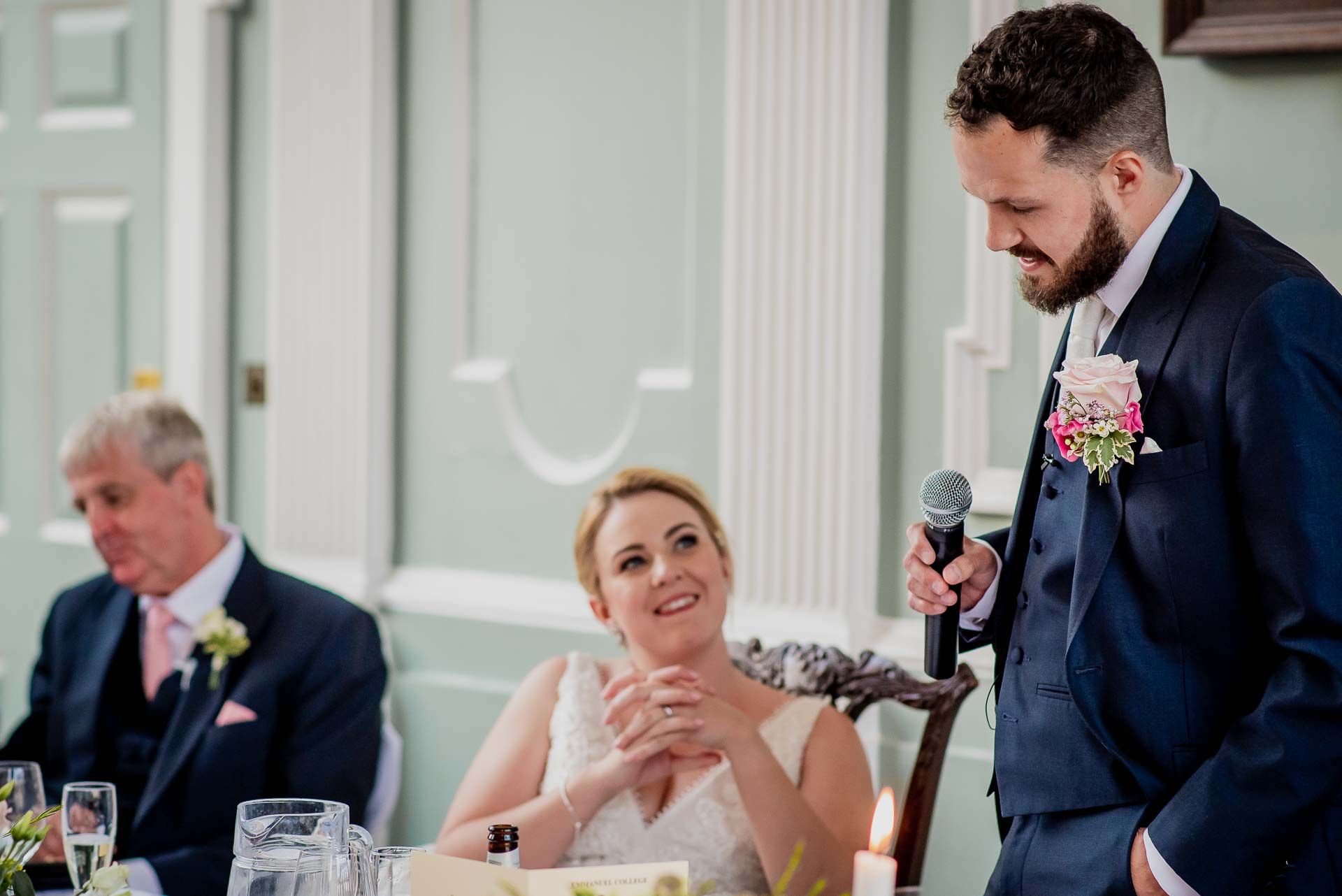 Nic giving his speech with his bride Leah watching and her Dad in the background. Beautiful, natural wedding photo by Damien Vickers Photography. 