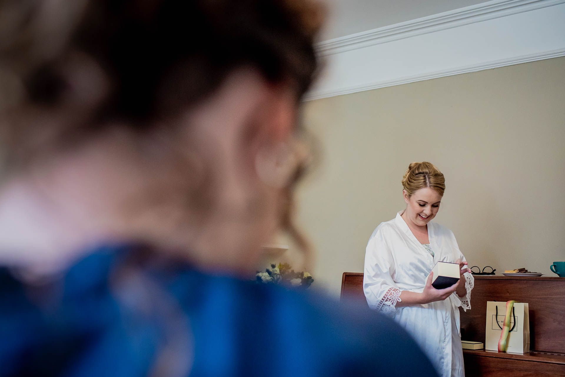 Leah opening presents the morning of her wedding at Emmanuel College in Cambridge. Photography by Damien Vickers Photography. 