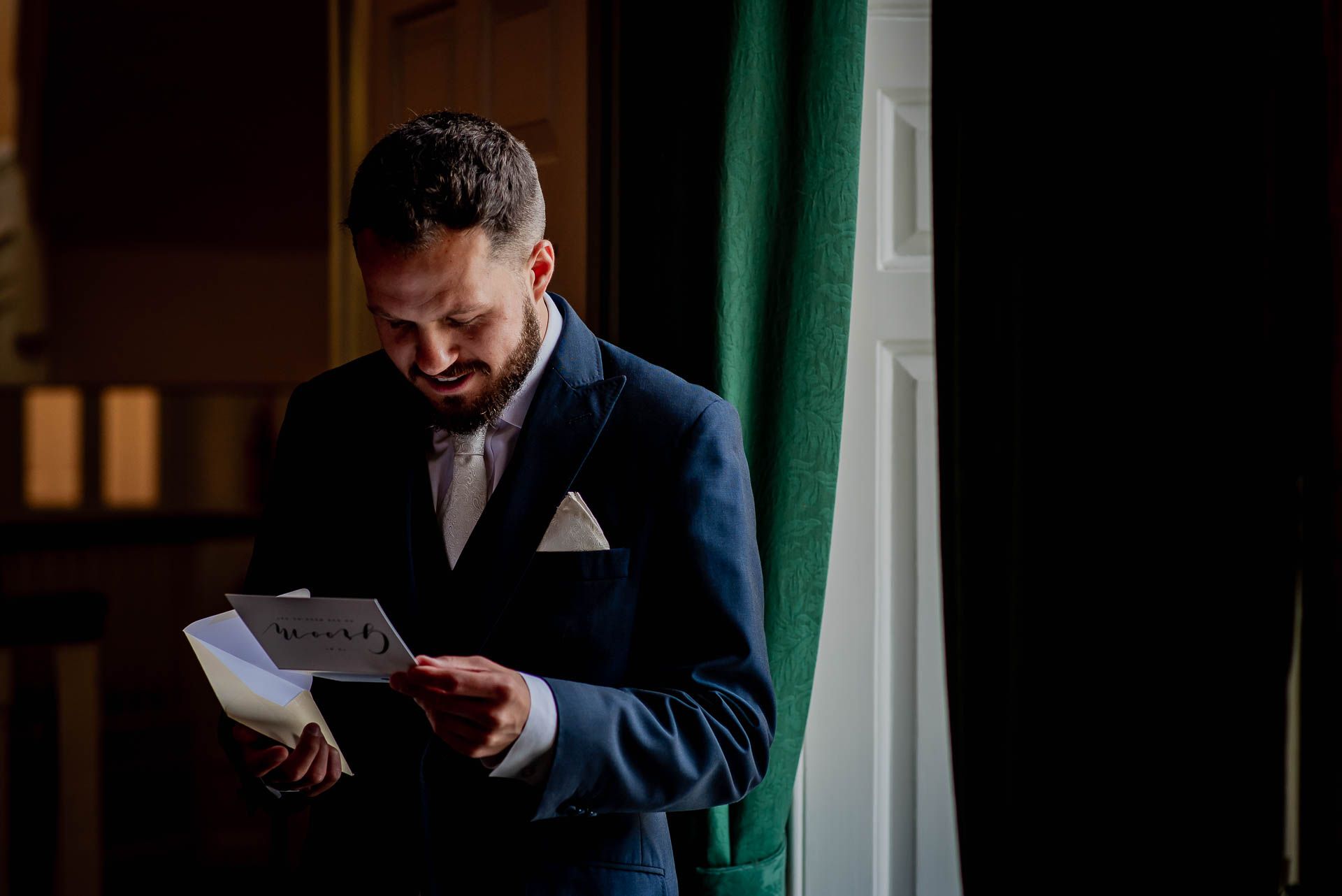 Nic opening his card from Leah on the morning of their wedding at Emmanuel College in Cambridge. Photography by Damien Vickers Photography. 