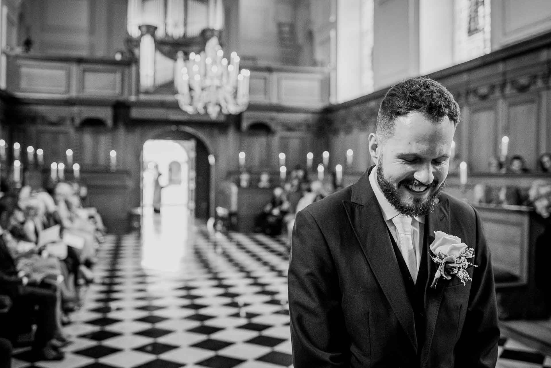 Nic waiting for Leah to arrive in the chapel ahead of their wedding ceremony at Emmanuel College in Cambridge. Photography by Damien Vickers Photography.