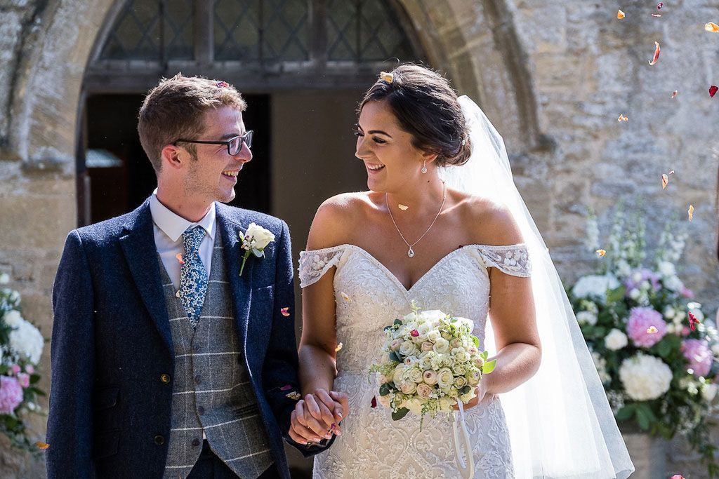 Rebecca and Mark exiting their church wedding ceremony as newlyweds - photography by Rob Wheal Photography | Oxfordshire wedding videography by Veiled Productions