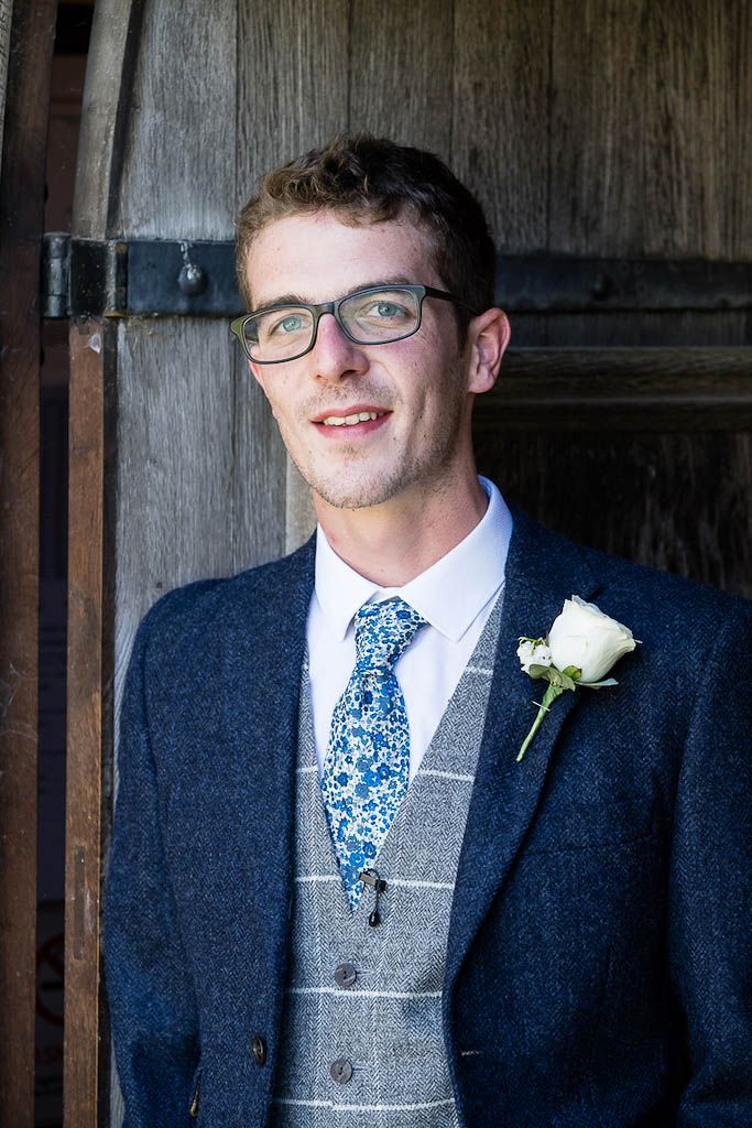 Mark - the groom - waiting at the church in a navy suit and blue floral tie - photography by Rob Wheal Photography | Oxfordshire wedding videography by Veiled Productions