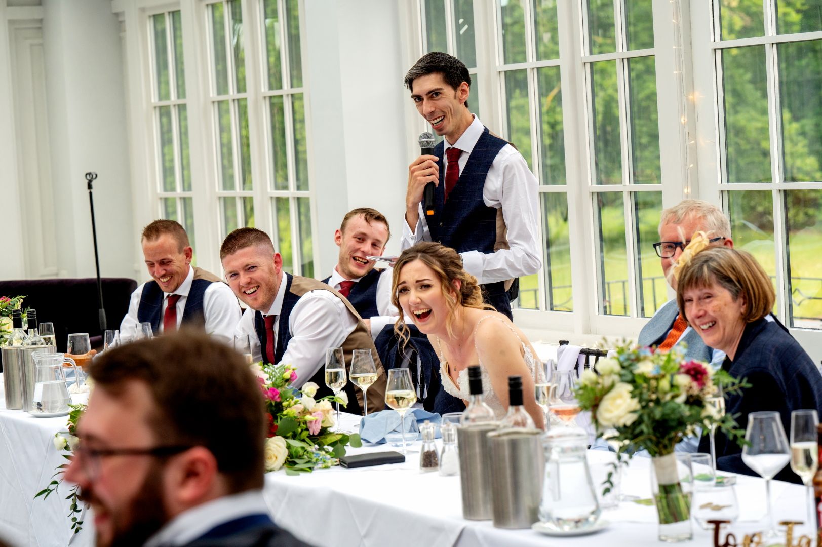 The top table laughing during Ross' speech at Swynford Manor. Photo by Fountain Photography.