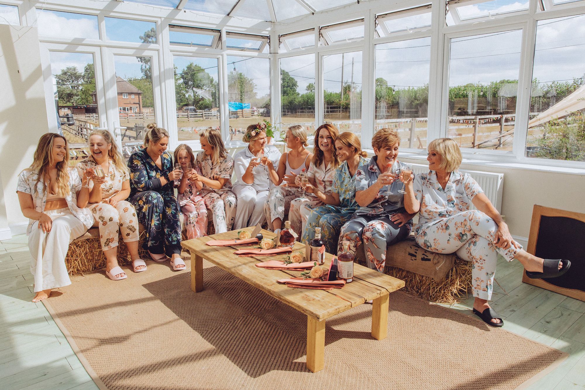 Nor and her bridesmaids in matching pajamas toasting the wedding with prosecco in the conservatory. Photo thanks to Fordtography.