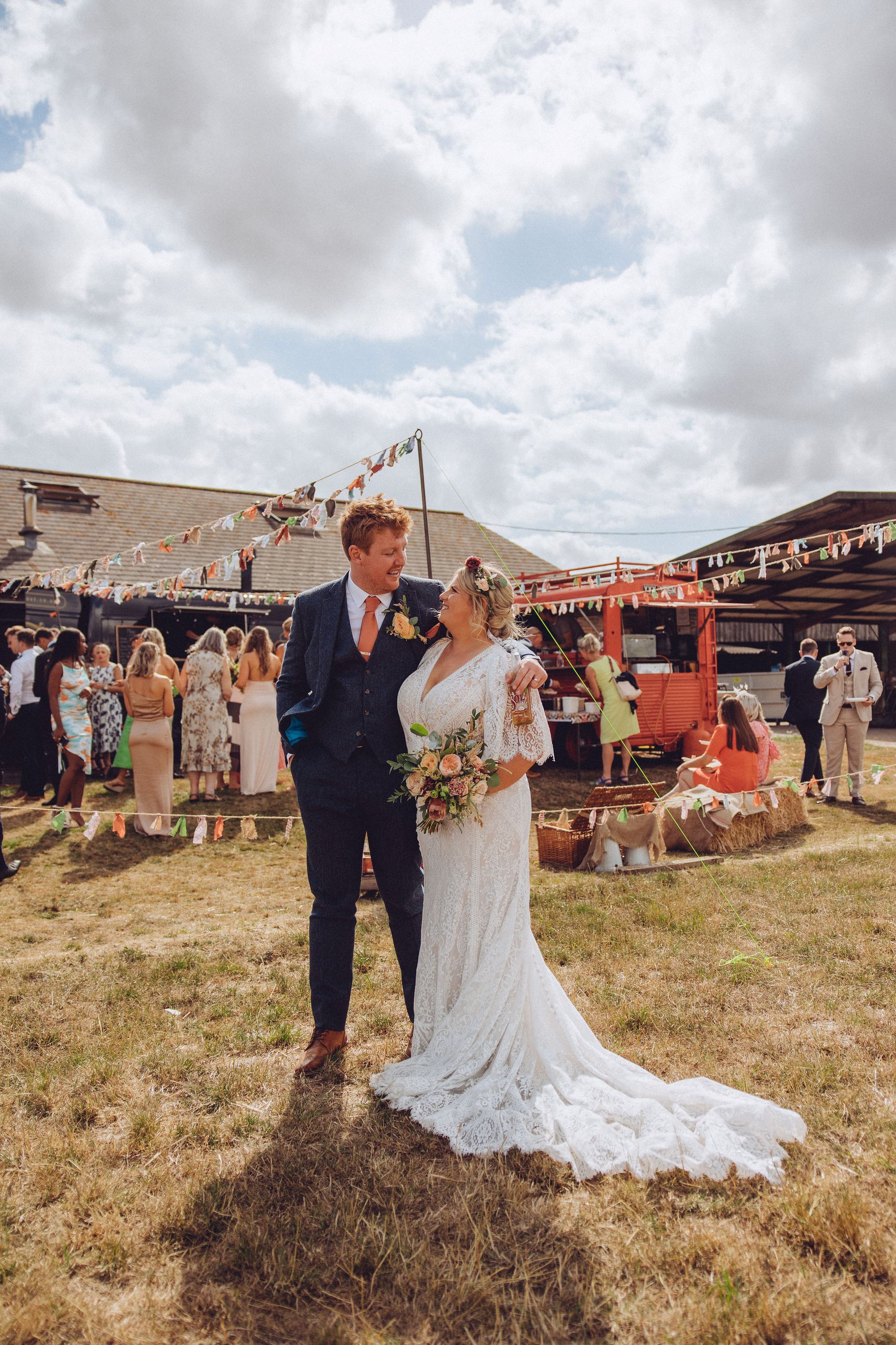 Dan and Nor smiling at each other in front of the street food vans during their wedding reception. Photo thanks to Fordtography.