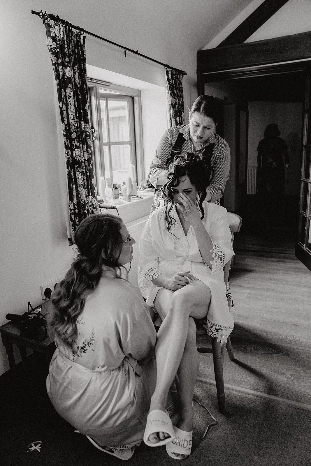 Bride Georgie crying happy tears whilst having her hair styled on the morning of her wedding at Huntsmill Farm. She's being consoled by her bridesmaid. Photo thanks to Sam and Steve Photography.