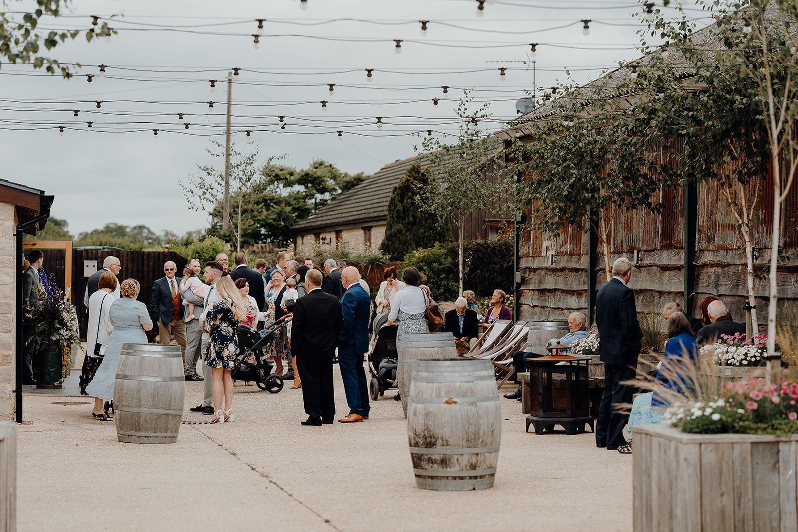 Georgie and James' guests in the courtyard at Huntsmill Farm prior to the wedding ceremony. Photo thanks to Sam and Steve Photography.
