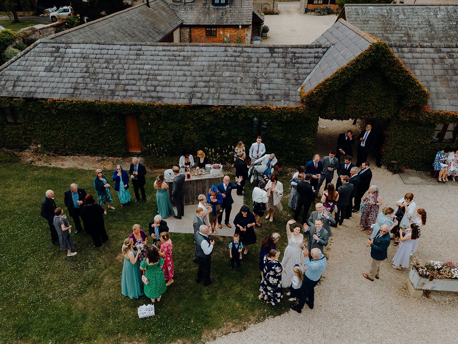 A photo of the drinks reception in Huntsmill Gardens from a drone. Bride Georgie is waving. Photo thanks to Sam and Steve Photography.