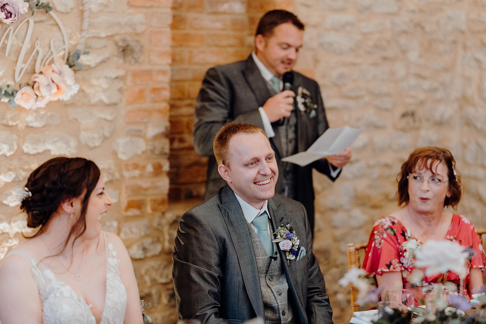 James' best man making a speech with James and Georgie laughing and Mother of the Bride pulling a surprised face! Photo thanks to Sam and Steve Photography.