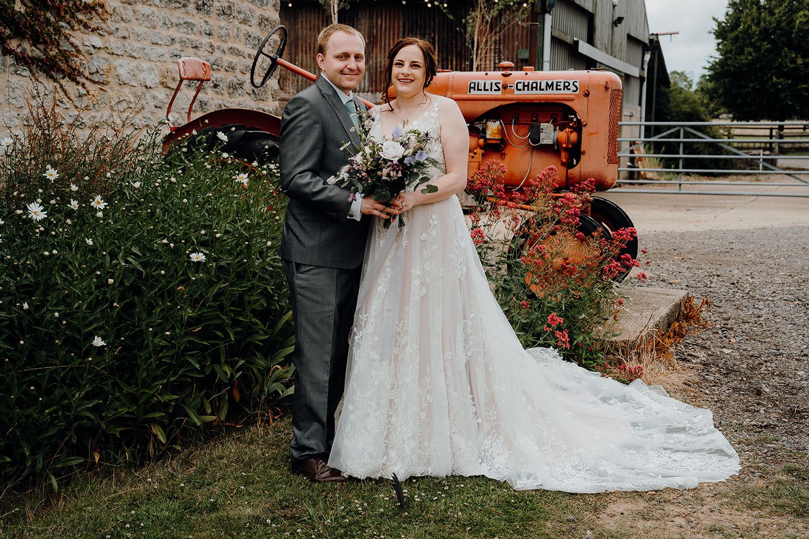 Georgie and James stood in front of the iconic old tractor at Huntsmill Farm. Photo thanks to Sam and Steve Photography.