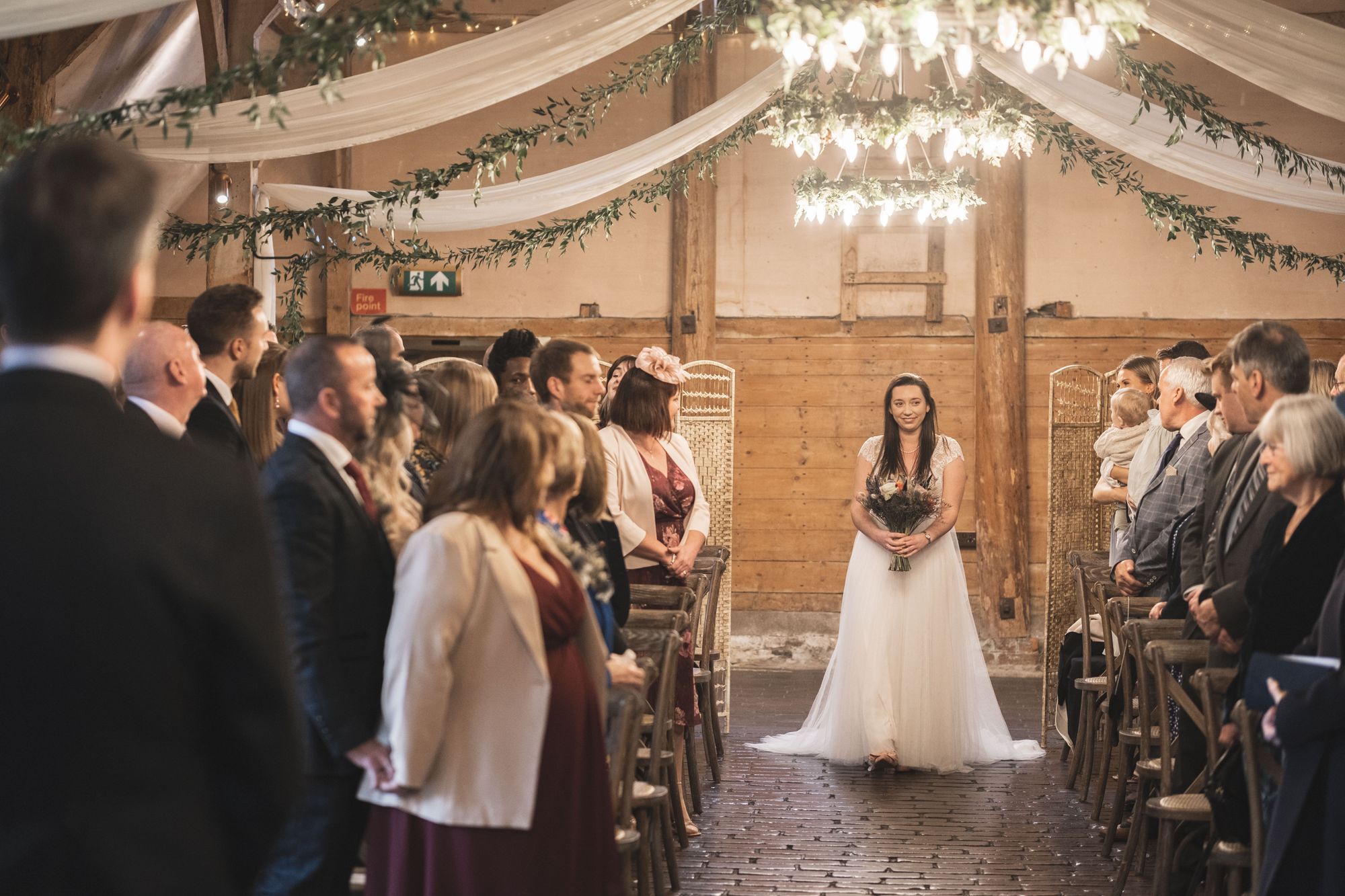 Jennifer walking down the aisle to James for their civil wedding ceremony at Lains Barn. Photo thanks to The Falkenburgs. 