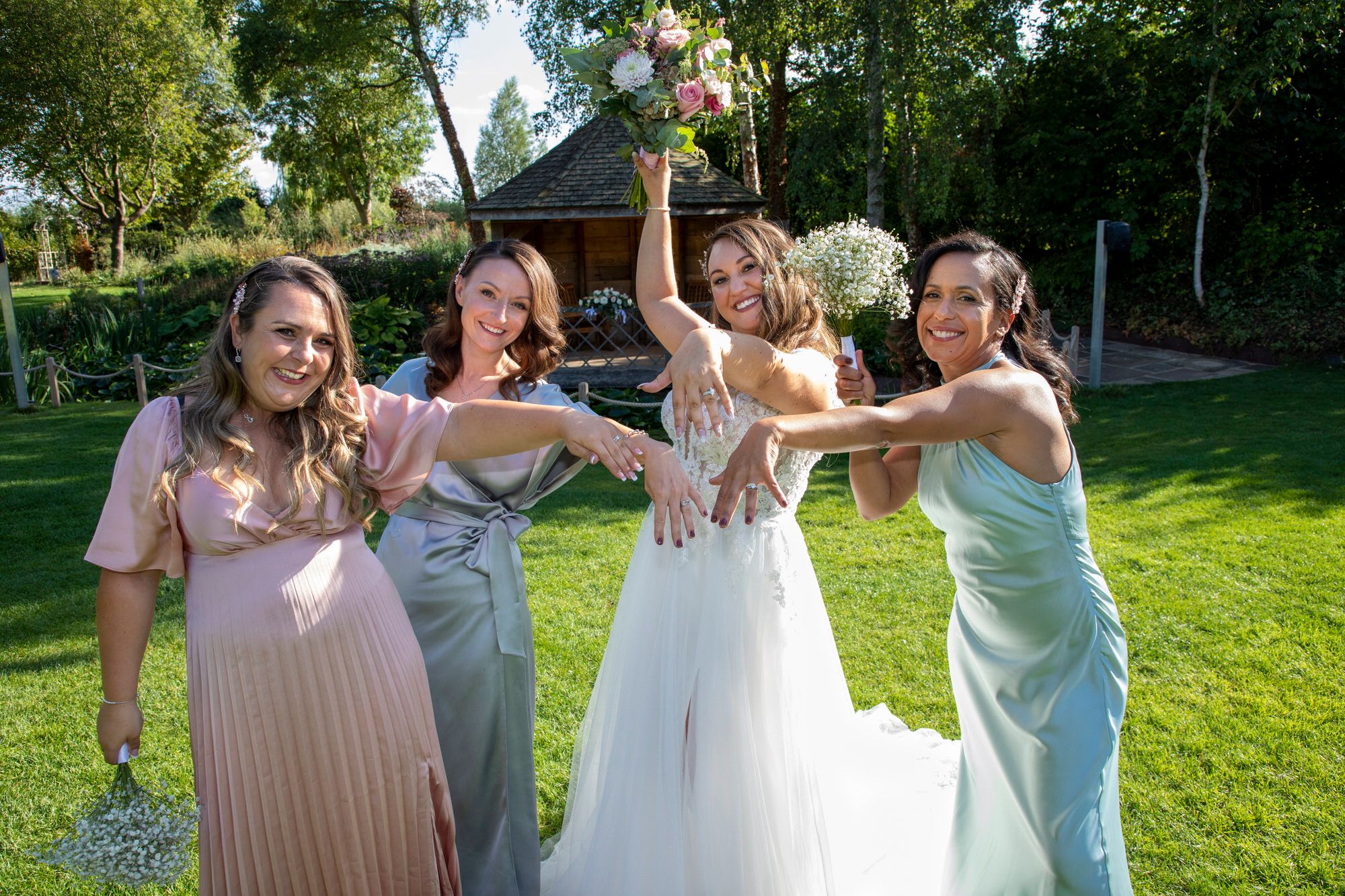 Joanna and her bridesmaids holding their ring hands in the centre - celebrating they are all married. Photo thanks to Nigel Charman Photography.