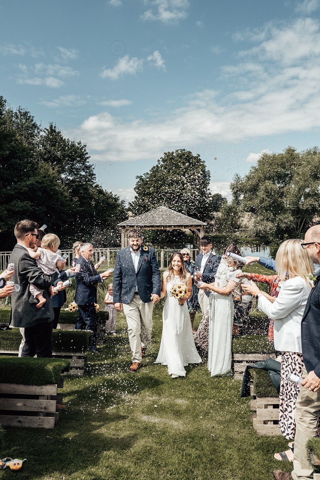 Incredible confetti photo as couple walk down the aisle after their ceremony on the lake at Furtho Manor Farm. Photo thanks to Francesca Checkley Photography.