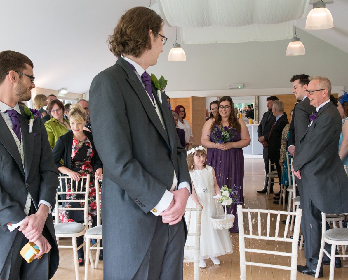 Finn stood at the top of the aisle watching his daughter throw flower petals at the bridesmaids follow behind in The Garden Room at Wasing Park. Photo thanks to Zoe Warboys Photography.
