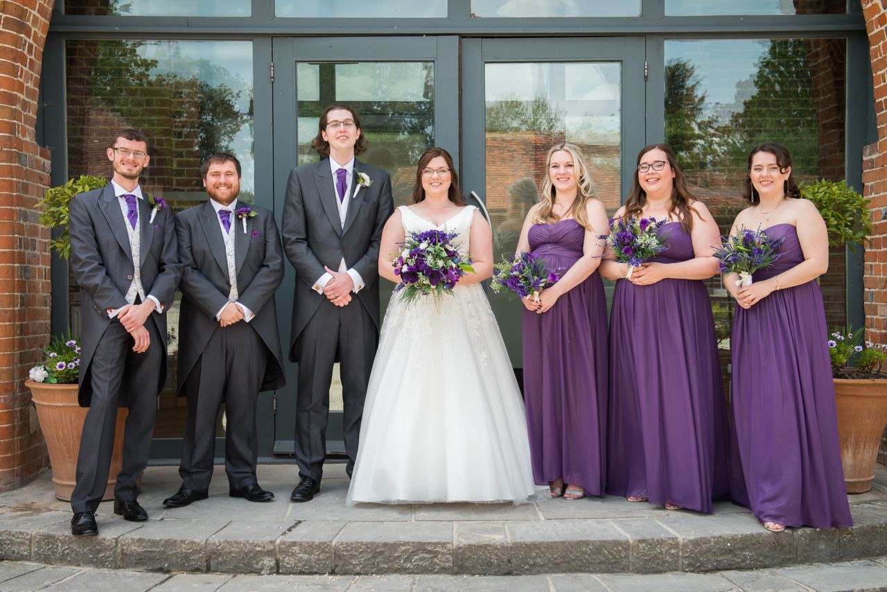 Zoe and Finn stood with their two groomsmen and three bridesmaids outside the Castle Barn at Wasing Park. Photo thanks to Zoe Warboys Photography.