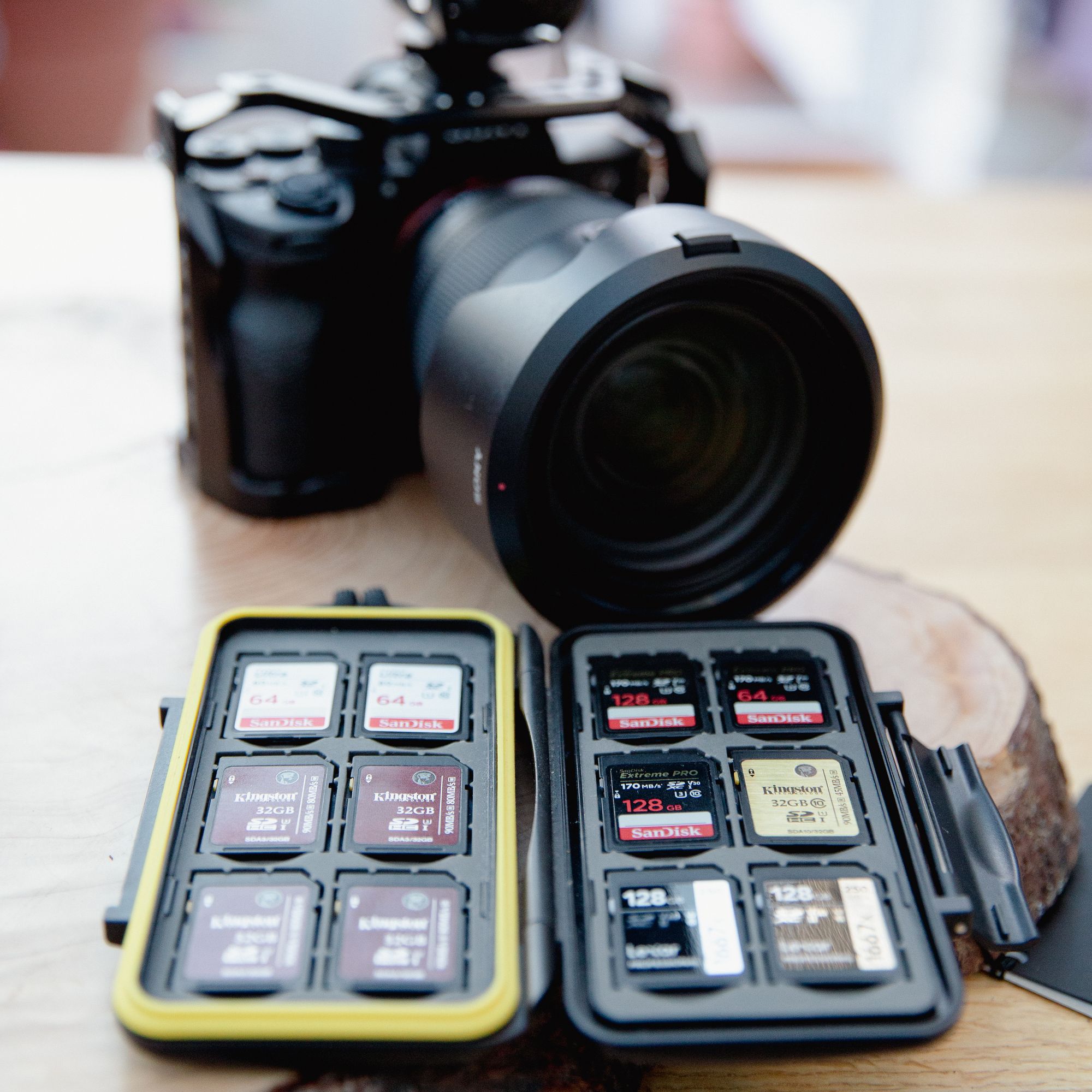 In the foreground are multiple SD cards in a case and in the background is a Sony A7SIII 4K camera with a Sony 24-70 lens