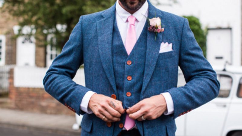 A groom dressed in a blue suit hired from The Vintage Suit Hire Company