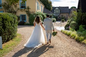 Joanna and Rafal walking hand in hand past the iconic farmhouse at South Farm.