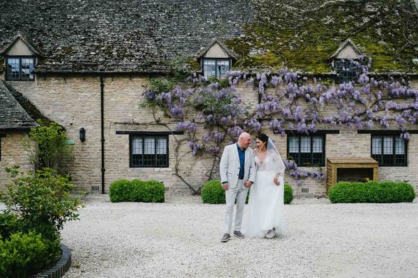 Adrian and Nadia holding hands in front of Minster Mill. 